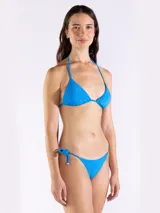 Top de bikini triangular color azul brillante, con tiras ajustables para anudar al cuello y la espalda. Cuenta con terminaciones metálicas decorativas en los cordones.