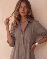 Vestido camisero midi blanco de lino, con cuello camisero, botonadura frontal completa con botones de nácar, mangas largas con tira para arremangar y abertura lateral en el bajo.