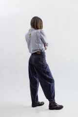 Pantalon de gabardina corte balloon, color azul oscuro, con costuras en contraste y diseño de paneles curvos. Presenta bolsillos traseros superpuestos y cierre frontal con botón metálico.