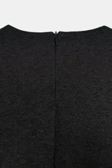 Top de manga larga con cuello redondo, confeccionado en tejido de sarga color tostado. Presenta un diseño entallado con trabillas laterales decoradas con botones dorados y cierre de cremallera en la espalda.