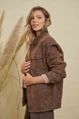 Campera de cuero marrón con efecto desgastado, corte oversize, cuello camisero, cierre frontal con botones y bolsillos frontales con solapa.