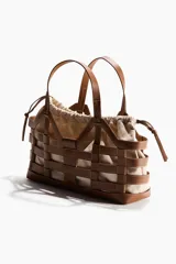 Bolso tipo tote grande de tela revestida marrón con estructura exterior trenzada imitando cuero y bolsa interior de lona de algodón y lino con cordón ajustable.