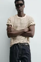 Camiseta color arena de algodón compacto, corte recto, cuello redondo y mangas cortas.