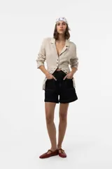 Camisa Riva de lino color beige, de calce relajado y silueta ligeramente oversized, con solapa y cierre frontal de botones.