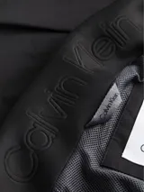 Chaleco negro Calvin Klein con cuello alto, cierre de cremallera, bolsillos laterales, bajo con cordón ajustable y logo tonal en el pecho.