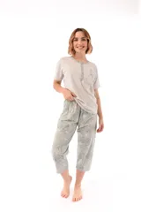 Conjunto de pijama de algodón color champagne, compuesto por una remera de manga corta con cuello henley y bolsillo en el pecho, y un pantalón capri a rayas horizontales celestes y blancas.