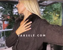 Saco tejido de punto con diseño de ochos, cuello con detalle de piel sintética, cierre frontal con botones al tono y mangas largas.