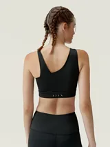 Top deportivo color beige con diseño asimétrico y tirante ancho en un hombro.