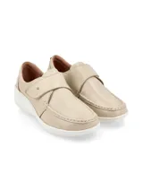 Zapato tipo slip-on color crudo, confeccionado en cuero, con cierre de velcro ajustable en el empeine, costuras visibles y suela de plataforma blanca.