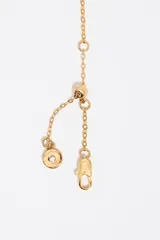 Collar de cadena dorada con un dije central con forma de pantera o leopardo en posición de marcha, con detalles de esmalte negro o piedras incrustadas simulando el pelaje moteado.