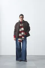 Campera acolchada de nylon color negro, con cuello alto, cierre frontal y botones a presión. Presenta un diseño de rombos y forro interior suave.