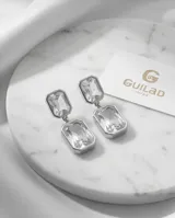 Caravanas colgantes de acero con diseño de doble rectángulo y piedras de cristal transparente.