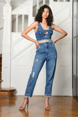 Pantalón de jean celeste con roturas, tiro alto, corte holgado y tobillos ajustados.