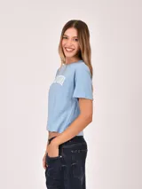 Remera de algodón color celeste con estampado frontal con la palabra California y detalles en las mangas.
