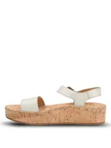 Sandalias Hush Puppies modelo Zug, de color plateado, con plataforma de corcho y capellada de cuero. Cuentan con tira en el antepié y tira trasera con hebilla metálica de ajuste.