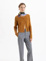 Cardigan de tejido de punto acanalado color marrón, con cuello redondo, mangas largas raglán y cierre frontal con botones a tono. Presenta un corte ajustado al cuerpo y largo a la cadera.