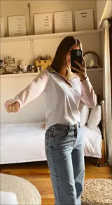 Remera blanca con mangas y cuello color beige, con logo bordado en el pecho.