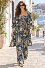Conjunto Triana Kastu de tres piezas compuesto por kimono de mangas amplias tres cuartos, top tipo bandeau con escote recto y pantalón largo de corte ancho y relajado. Todo el conjunto confeccionado en tejido fluido con un llamativo estampado botánico y de leopardo sobre base negra.