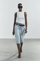 Bermuda jorts de denim celeste con efecto lavado, tiro bajo y cinco bolsillos. Cierre frontal con cremallera y botón metálico.