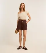 Short de mujer de sarga color beige claro, tiro alto, con pespunte contrastante en color blanco o crema. Presenta un corte regular y bolsillos delanteros y traseros.