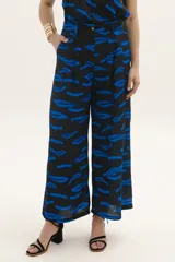 Pantalón palazzo negro con estampado de pinceladas azules, tiro alto y corte amplio.
