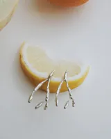 Aros colgantes con diseño orgánico inspirado en corales naturales, con acabado metálico brillante y cierre de perno con mariposa.