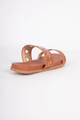 Sandalias bajas color suela, con doble tira en el empeine. La tira superior presenta argollas metálicas doradas.