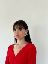 Aros con diseño de flor, compuestos por pétalos en color crema y un centro decorado con cristales en tonos rosados.