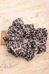 Scrunchie con estampado animal print en tonos beige, marrón y negro.