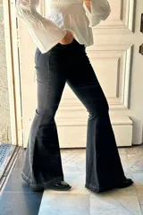 Pantalón de jean negro con corte oxford, de tiro medio y botamanga acampanada con ruedo deshilachado.