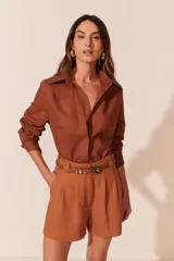 Camisa manga larga color marrón con cuello clásico y cierre con botones.