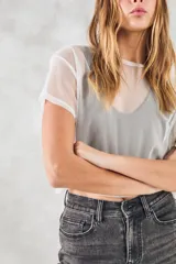 Remera corta de tul blanco, de corte holgado y mangas cortas.