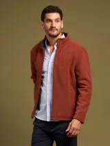 Campera de poliéster color ladrillo con cierre frontal, cuello alto y bolsillos laterales.