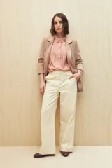 Camisa blanca de manga larga con cuello clásico y botones de nácar. Presenta detalles calados en el frente.