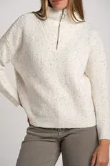 Sweater de punto texturado en color beige melange con motas de colores, diseño oversize, cuello alto con cierre frontal y mangas largas.