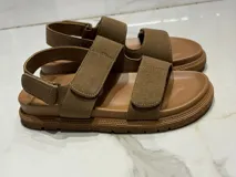 Sandalias color beige con ajuste de velcro en capellada y talón, plantilla acolchada y suela de goma antideslizante. Horma chica.