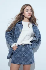 Minifalda de jean con estampado cuadrillé en tonos azules, de corte recto y estructura clásica con bolsillos.