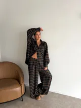 Pantalón de corte recto y holgado, confeccionado en tela de viyela con estampado de cuadros en tonos negro, gris y blanco. Presenta cintura elástica para mayor comodidad.