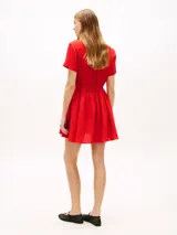 Vestido corto rojo de lino de Tommy Hilfiger, con cuello camisero, manga corta, cierre frontal con botones ocultos, cordón ajustable en la cintura y bolsillos laterales.