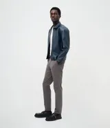 Pantalón slim de sarga lavada color gris, de corte ajustado, con trabillas en la cintura y cierre de botón y cremallera.