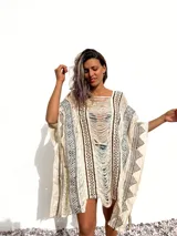 Poncho de tejido rústico color crudo con estampado geométrico en marrón y flecos.