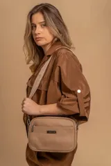Bandolera de diseño rectangular con textura granulada, cuenta con tres compartimentos principales con cierre, un bolsillo frontal y correa ajustable de cinta reforzada.