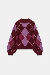 Jersey de punto de lana con diseño de rombos en tonos bordó y lila. Presenta cuello redondo, manga larga con puños ajustados y corte holgado.