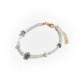 Pulsera de cuentas facetadas color celeste, con detalles de perlas, piedras grises irregulares y herrajes dorados.