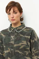 Sobrecamisa de estilo militar con estampado de camuflaje, cuello clásico, cierre frontal con botones y mangas largas. Presenta detalle de flecos en cuello, mangas y espalda.