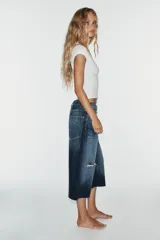 Bermuda de jean tiro medio, corte baggy y diseño holgado con detalle de rotos y cinco bolsillos.