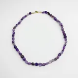 Collar elaborado con cuentas de amatista natural de formas irregulares y cierre metálico con baño de oro.