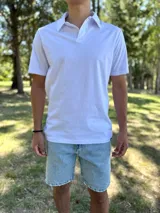 Remera chomba blanca de manga corta, con cuello polo y cierre frontal de botones ocultos.