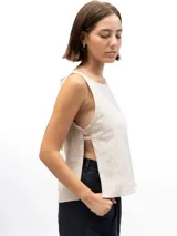 Musculosa de lino con cuello redondo, diseño holgado y laterales abiertos unidos por tres tiras horizontales.