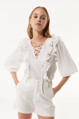 Short color crema de tiro alto con bolsillos laterales y ruedo doblado.